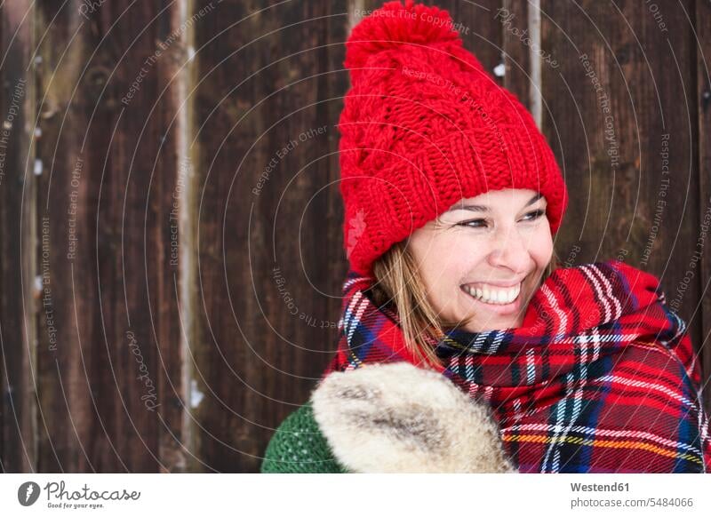 Portrait of smiling woman wearing red bobble hat in winter portrait portraits laughing Laughter females women positive Emotion Feeling Feelings Sentiments