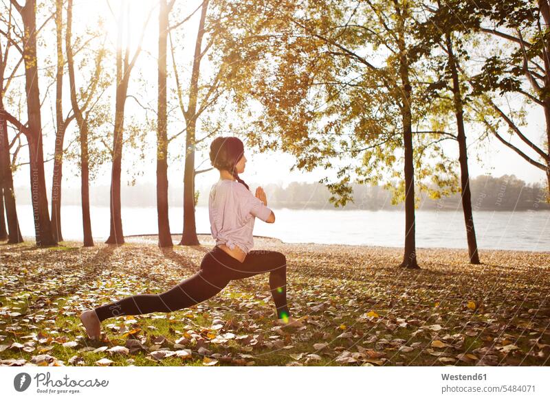 Woman in nature holding a yoga pose woman females women exercise exercises standing Adults grown-ups grownups adult people persons human being humans