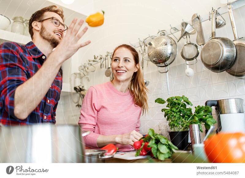Happy young couple cooking together in kitchen happiness happy twosomes partnership couples people persons human being humans human beings home at home
