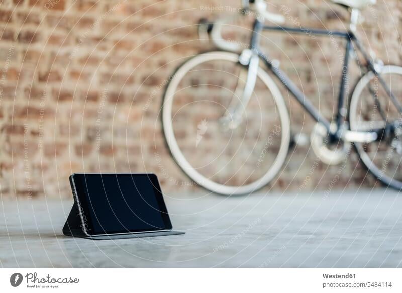 Tablet and bicycle in a room with brick wall business business world business life occupation profession professional occupation jobs accessibility accessible
