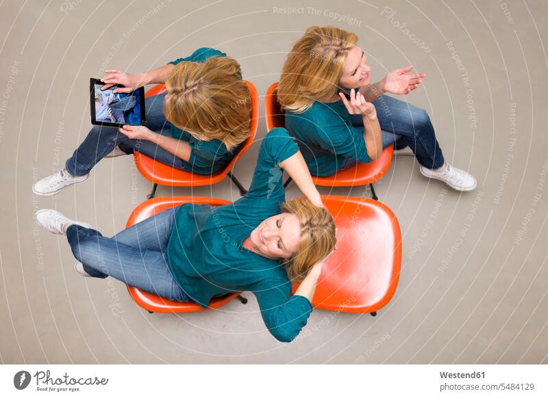 Woman sitting on chairs using portable devices, multitasking blond blond hair blonde hair overhead view directly above top view Wifi Wi-Fi wireless internet