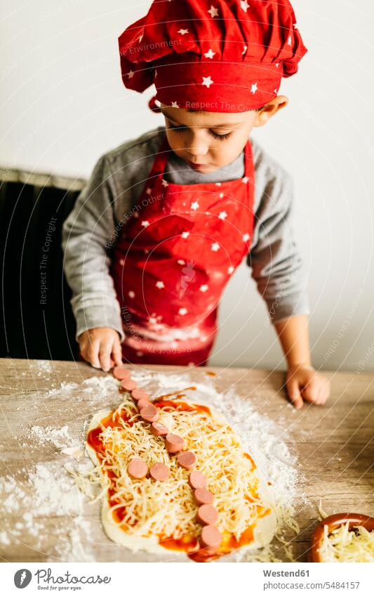 Little boy preparing pizza at home boys males kitchen domestic kitchen kitchens cooking child children kid kids people persons human being humans human beings