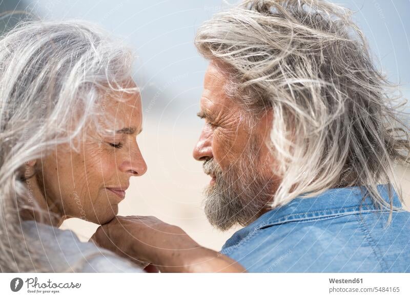 Affectionate senior couple looking into each others eyes in front of the sea beach beaches vacation Holidays attractive beautiful pretty good-looking