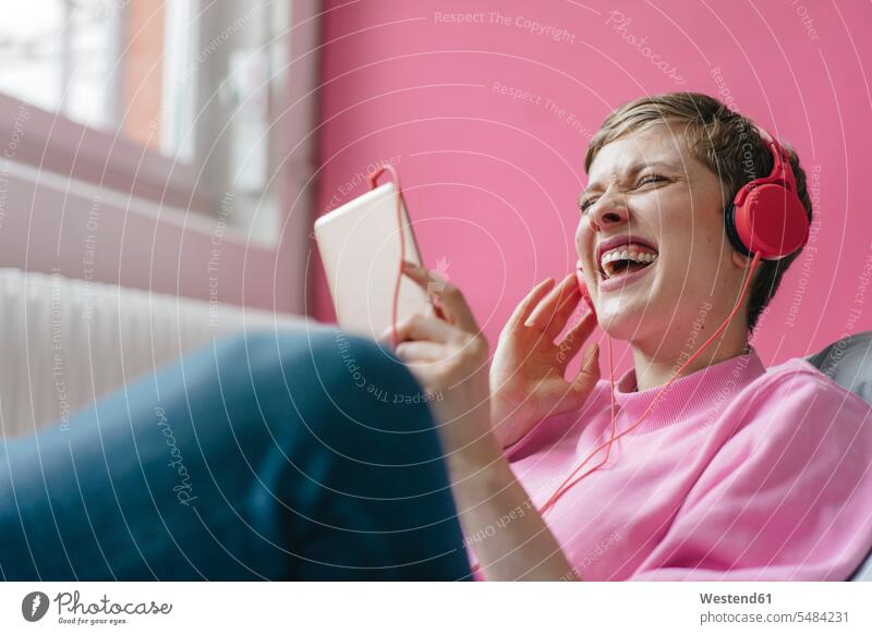 Screaming woman with cell phone and headphones listening to music mobile phone mobiles mobile phones Cellphone cell phones screaming shouting hearing females
