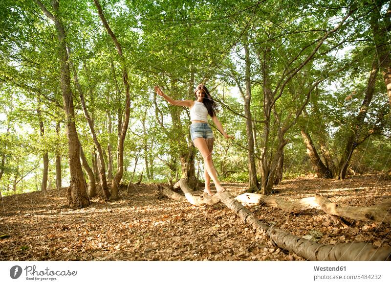 Young woman in forest balancing on a log Tree Trees females women smiling smile woods forests balance Adults grown-ups grownups adult people persons human being