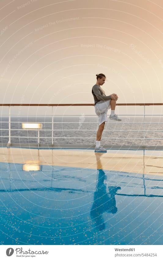 Young man doing exercises on a shipdeck, cruise ship, Mediteranean Sea on board aboard workout working out work out sport stretching journey travelling Journeys
