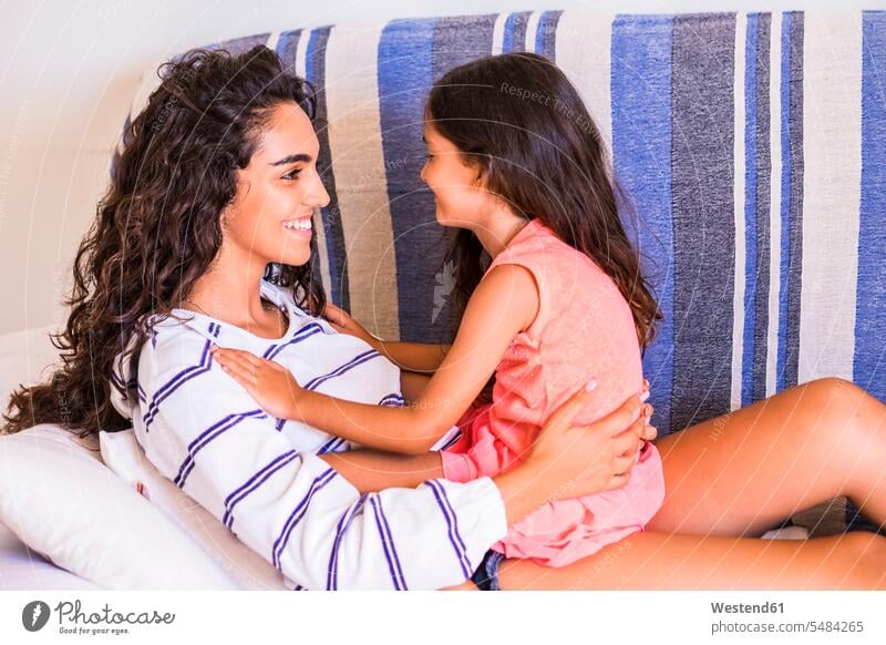 Smiling teenage girl and her little sister facing each other happiness happy females girls sisters smiling smile child children kid kids people persons