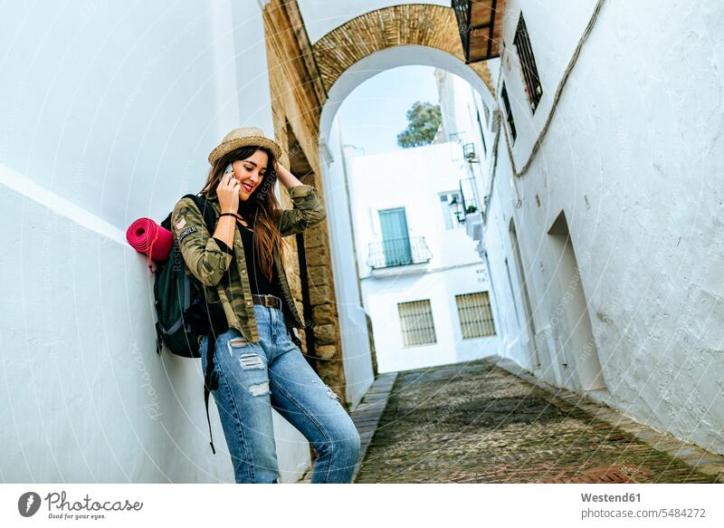 Young traveling woman talking on cell phone in a town females women on the phone call telephoning On The Telephone calling mobile phone mobiles mobile phones