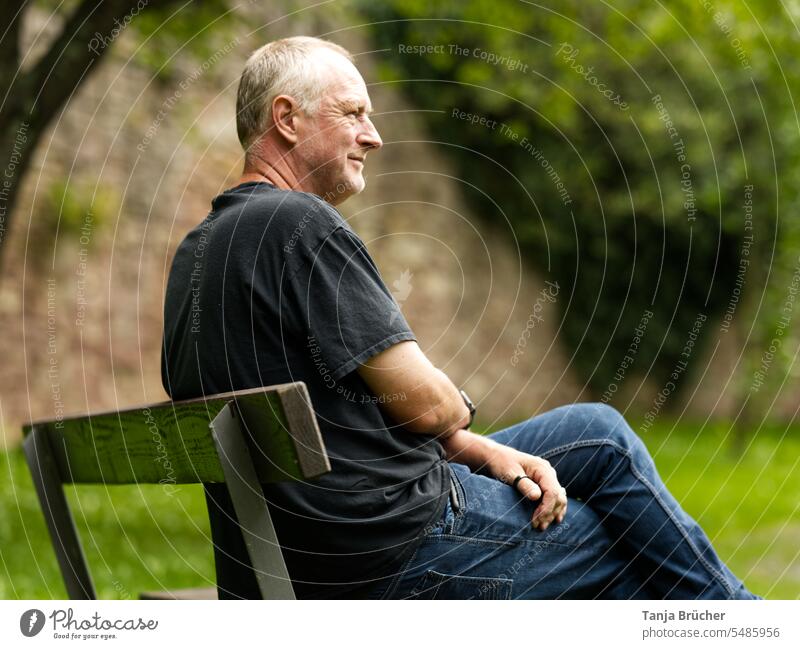 Middle aged man sitting on park bench looking into distance Man Only one man middle-aged man Mature man Mid adult man 50 - 55 years Longing attentiveness
