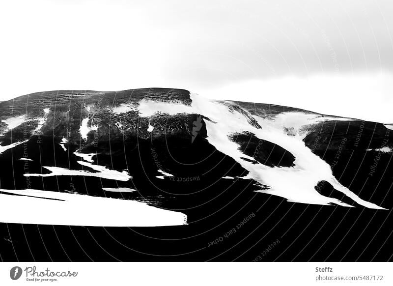 Snow melting on the mountain side in Iceland Icelandic shape Abstract Mountain side Snow forms Iceland picture Northeast Iceland iceland trip Gray Sky gray