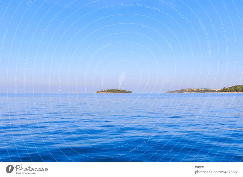 three flat islands on a sunny day with blue sky in the sea near Rovinj in Croatia Sea Water copy space drip drowning historical humid landscape nature nobody
