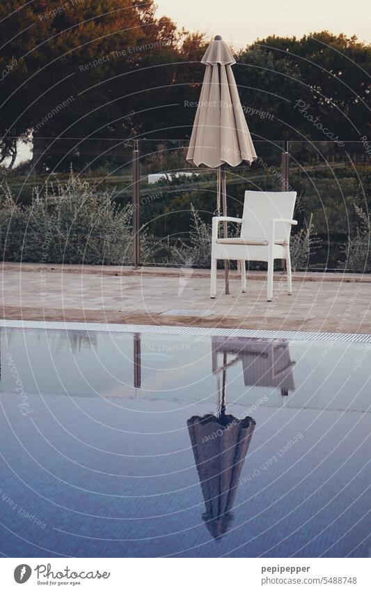 Evening atmosphere - folded parasol behind a chair by the pool Swimming pool Water Summer Blue Wet Swimming & Bathing Relaxation be afloat Refreshment