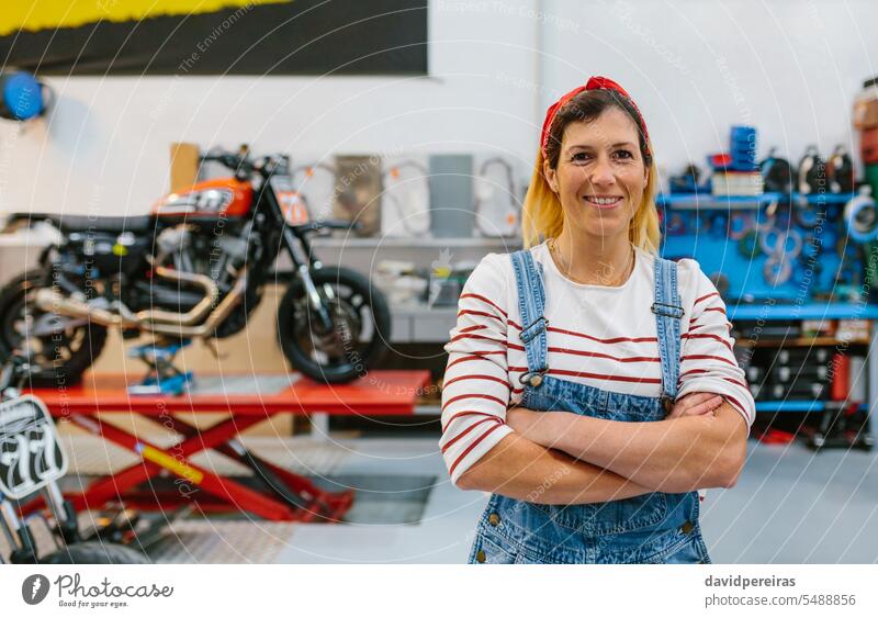 Portrait of mechanic woman standing on motorcycle factory portrait female smile smiling happiness happy looking camera motorbike platform profession worker
