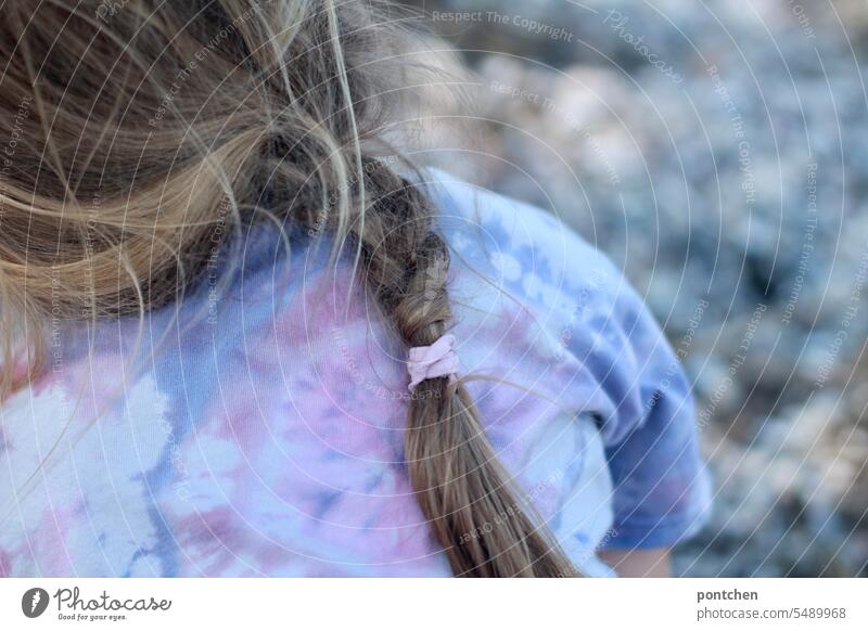 braided plait on batik t-shirt. a child sits on pebbles. Girl Batik Fashion garments Pebble Braids hairstyle braided hairstyle Style Child