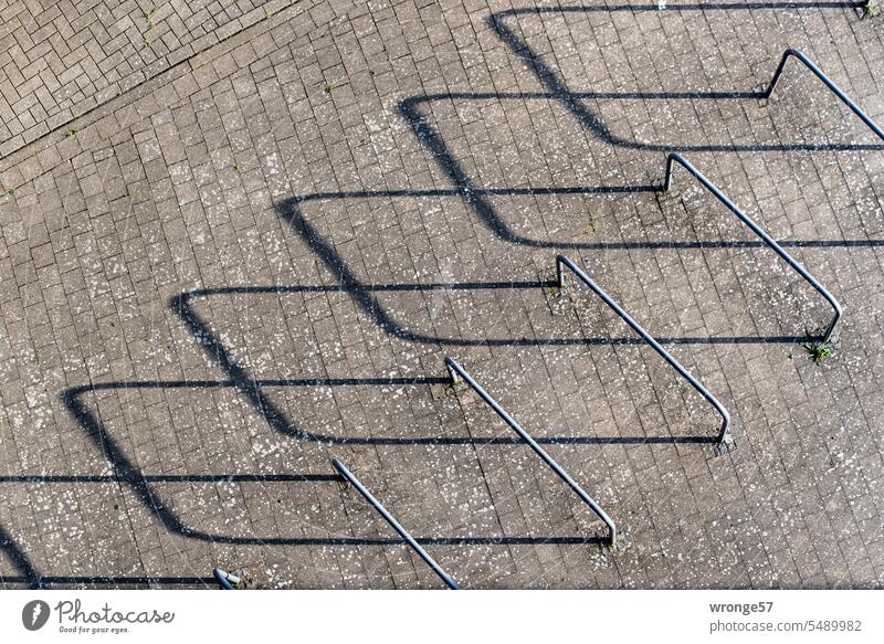 Bird's eye view of bicycle lean-to and long shadows Bicycle lean-to Bicycle hanger Leaning bracket Bird's-eye view plan Shadow flat sun position Abstract