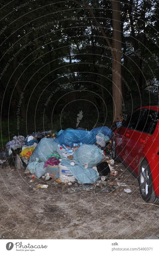 Illegal dumping of garbage in a public parking lot at the edge of a park in Germany in the twilight... Trash waste illicit Waste management Garbage dump