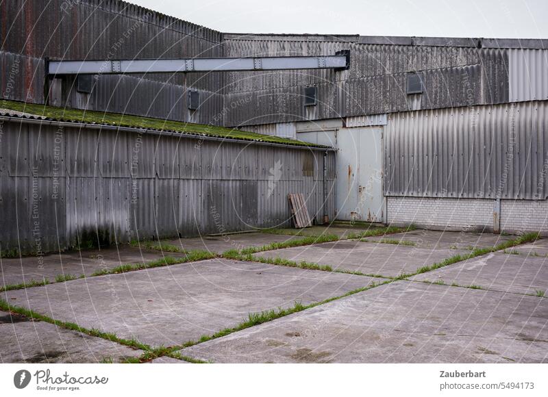 Industrial building, corrugated metal facade, pipeline and yard with concrete slabs Industry Building Corrugated sheet iron Concrete Places Gray