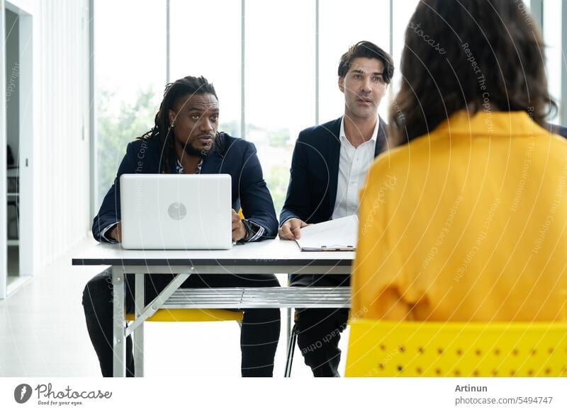 Job interview concept. Diverse hr team doing job interview with a woman in business office. Human resources team interviewing a potential job candidate. Hiring, employment, and recruitment concept.