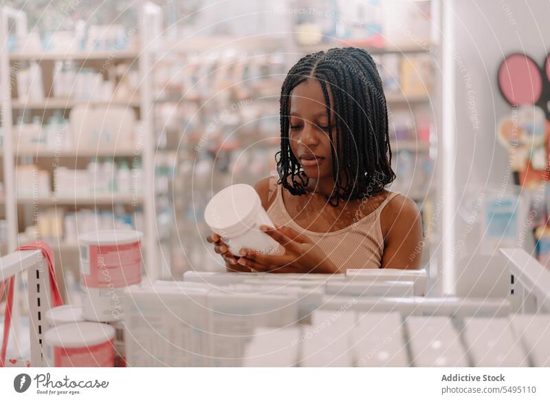 Black woman reading information on drug bottle at store buy customer pharmacy drugstore confident young product client medicine prescription lifestyle