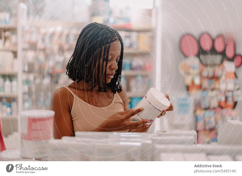 Black woman reading information on drug bottle at store buy customer pharmacy drugstore confident young product client medicine prescription lifestyle