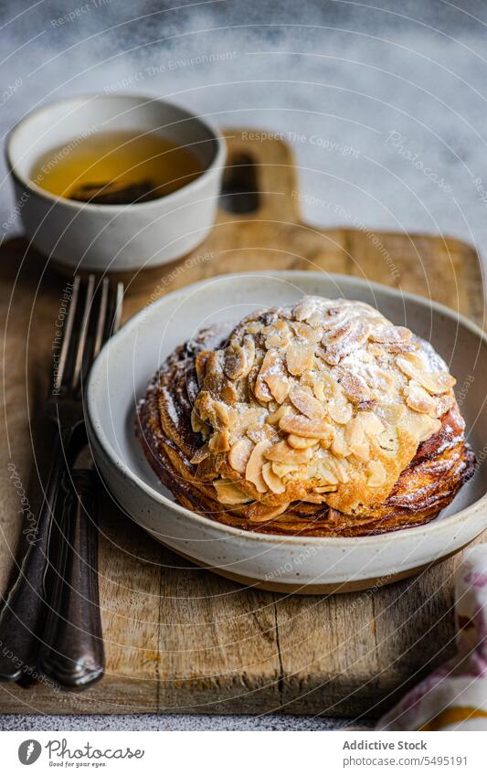 Sweet almond pastry on the plate with cup of green tea sweet chopstick wooden fork knife dish surface table high angle from above blur blurred background food