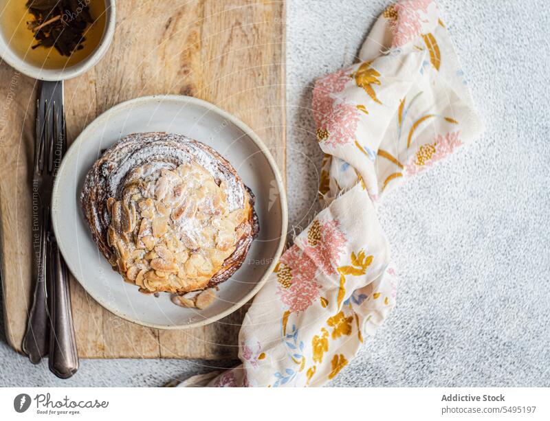 Sweet almond pastry on the plate with cup of green tea sweet chopstick wooden fork knife dish surface table high angle from above food drink dessert eat yummy