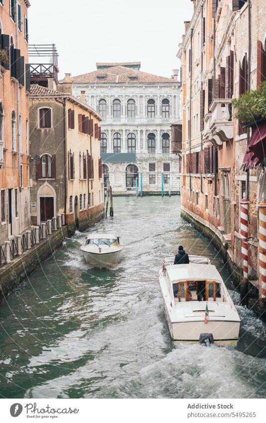 Waterway with ferry at ancient city street old water line overcast cloudy architecture town travel historical canal landmark venice italy brick building