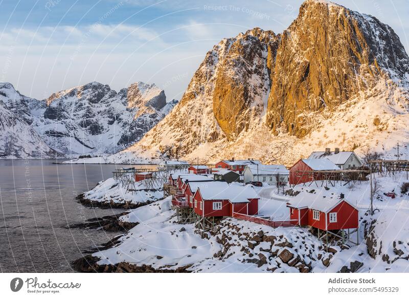 Houses near sea in mountainous valley in winter on a sunny day landscape ridge formation house rocky coast cottage shore snow cold freeze scenery settlement