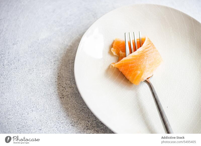Healthy salmon slice on white plate dish healthy food table surface yummy fresh nutrition nutrient fork menu high angle from above fish diet meal dinner cuisine