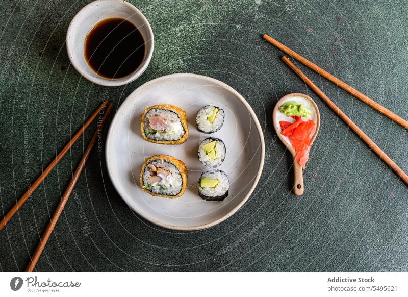 Top view of japanese food placed on a white concrete table serve set sushi roll bowl salmon rice seaweed soy sauce asian food chopstick healthy cookery culinary