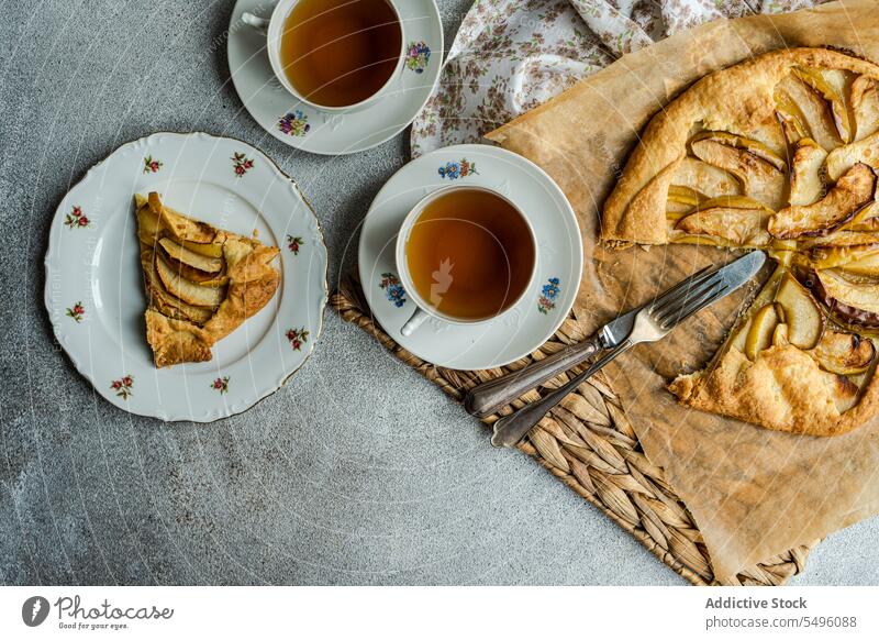 Apple galette and tea served on the concrete modern table apple pie piece cup teacup rustic tray gray food drink beverage liquid hot dessert yummy taste tasty