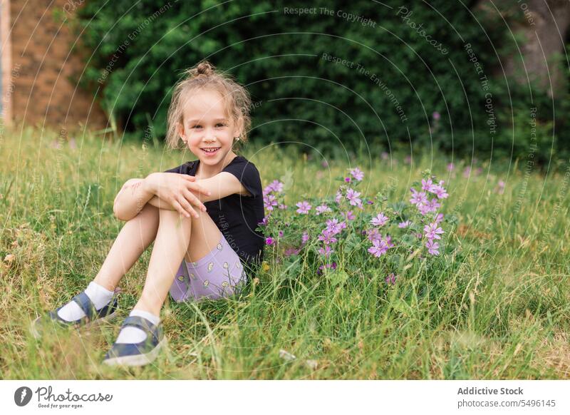 Smiling girl on grassy field near flowers nature kid happy child bloom blossom adorable childhood summer flora cheerful floral environment meadow positive smile