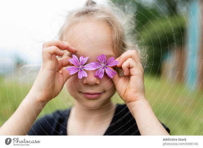 Little girl with small flowers child summer purple portrait kid cover eyes little delicate cute mallow adorable innocent fresh nature childhood gentle tender