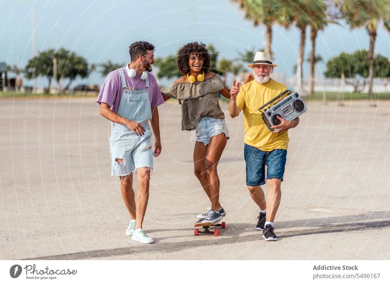 Happy family walking on street with skateboard ride laugh happy music having fun positive diverse skater excited enjoy activity energy multiethnic optimist glad