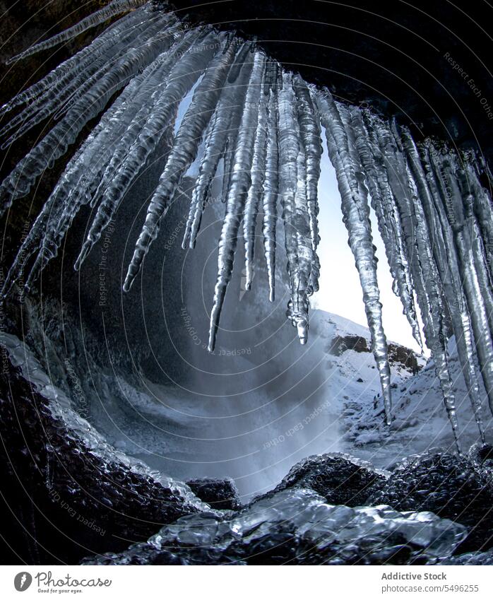 Amazing view of frozen dripping river water depositing from ceiling in winter cliff rock waterfall nature countryside rocky mountain formation stalactite