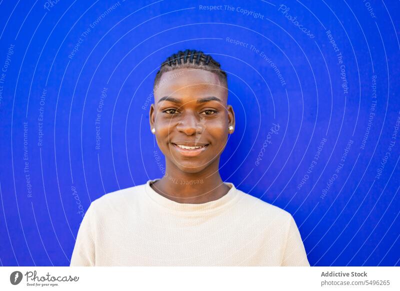 Cheerful teenage boy in white t shirt in studio confident smile appearance positive portrait style glad male braids young african american ethnic happy
