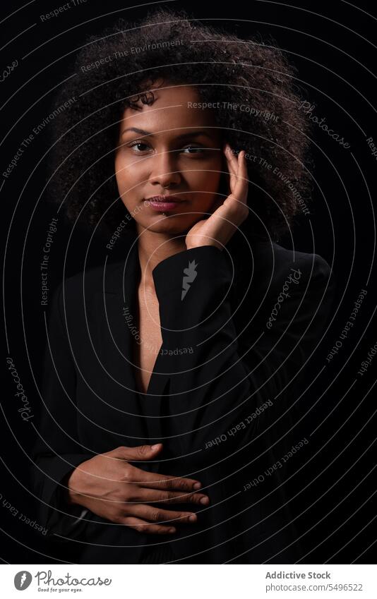 Ethnic woman touching face and looking at camera portrait curly hair appearance calm touch face model touch hair self assured confident individuality hispanic