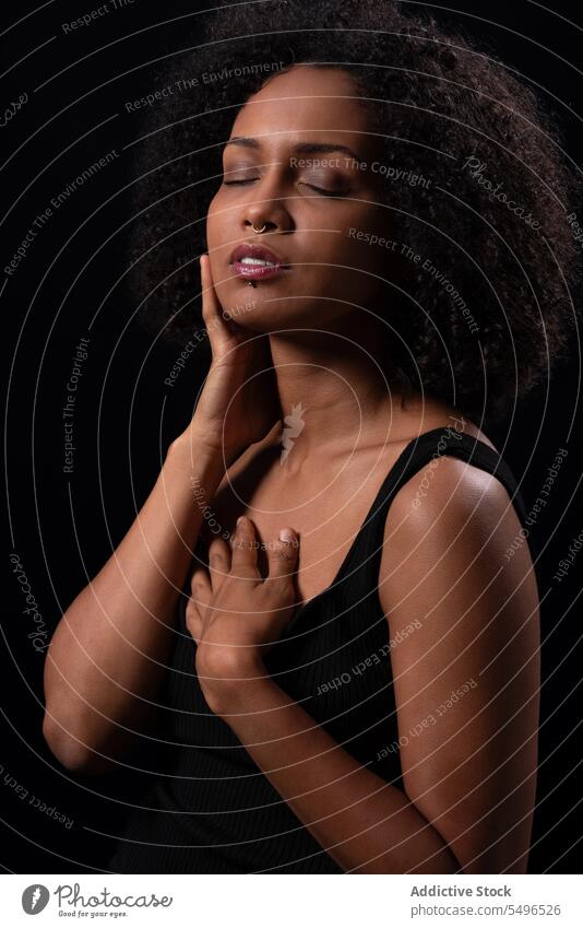 Ethnic woman touching face with closed eyes in studio self relax calm individuality dreamy youth style enjoy feminine curly hair self care self love hipster