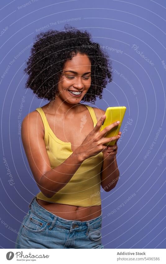 Happy ethnic woman using cellphone smartphone online smile cheerful browsing happy afro gadget device curly hair internet mobile positive top connection surfing