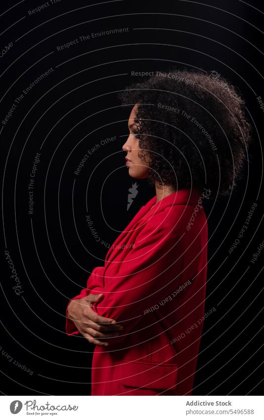 Thoughtful ethnic woman in red trendy outfit serious coat arms crossed contemplate thoughtful millennial model style confident afro appearance female young