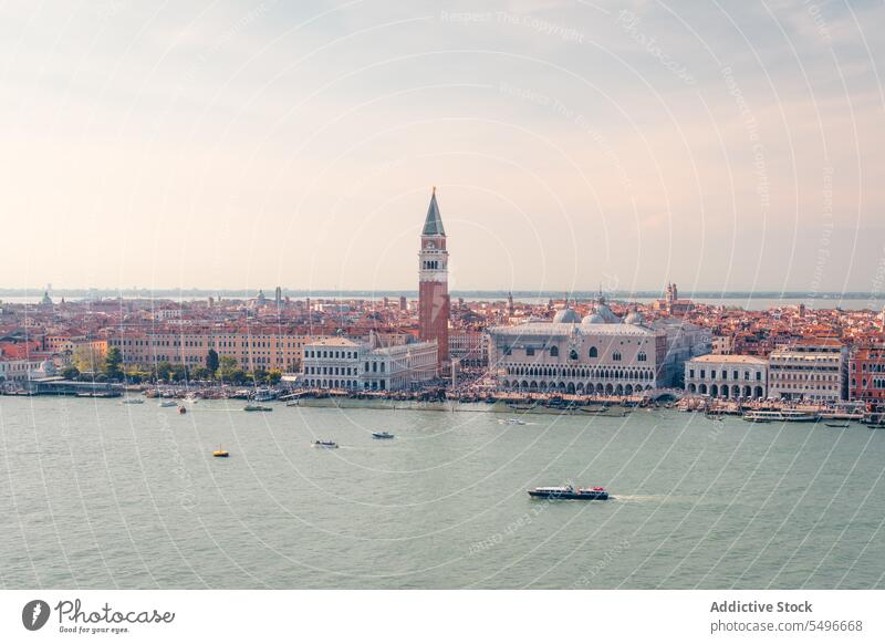 Boats floating on channel near historic buildings in sunlight architecture basilica canal vaporetto sightseeing landmark culture city sunset tower church venice