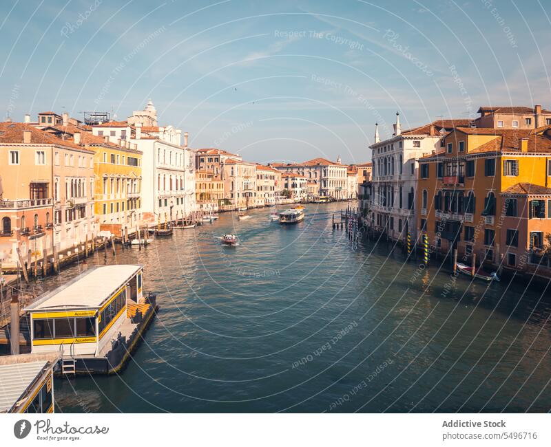 Boats floating on channel near historic buildings in sunlight architecture canal vaporetto sightseeing landmark culture city tower venice italy scenic exterior