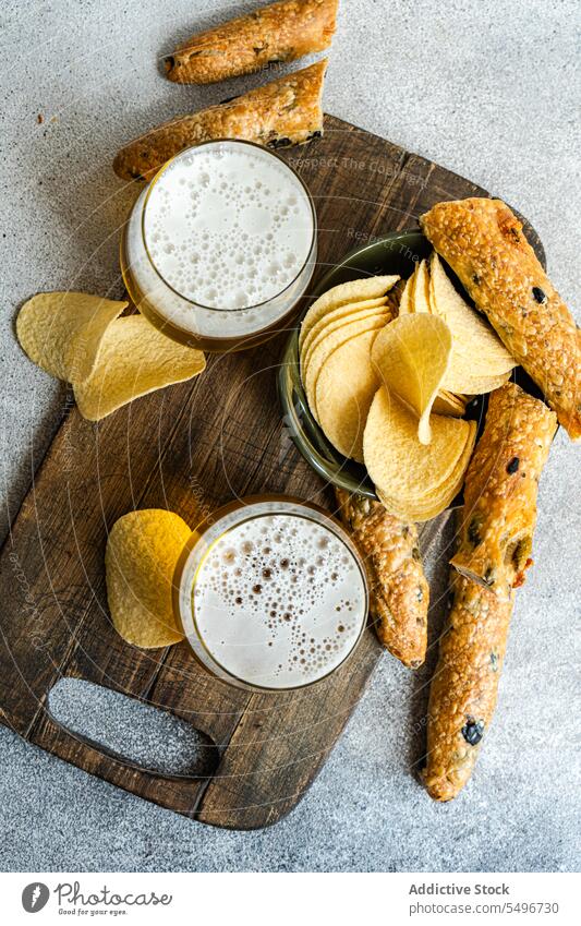 Crispy potato chips with bread and glasses of beer fries can fast food snack delicious tasty cutting board junk food meal empty canned yummy wooden portion