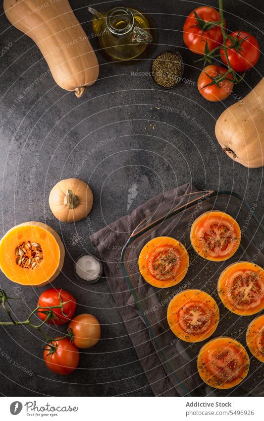 Whole and sliced butternut squash and tomatoes on glass board vegetable fresh ripe pumpkin organic natural food vitamin kitchen vegetarian ingredient raw whole