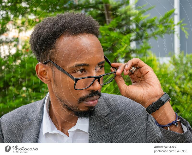 African American man in eyeglasses looking away on street formal elegant attentive executive contemplate appearance male ethnic black african american guy