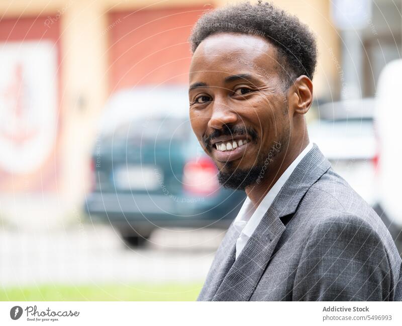 Cheerful young black businessman sitting in formal suit in daylight street confident smile cheerful urban automobile car male african american ethnic positive