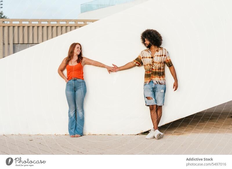 Multiethnic couple holding hands walk love together bonding romantic relationship date amorous boyfriend girlfriend smile happy positive young diverse