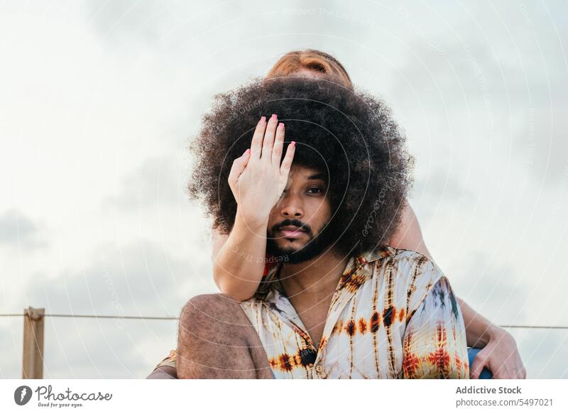 Hand covering eye of black man with Afro hair couple cover eyes hairstyle together trendy leisure afro cool serious woman curly hair casual close appearance