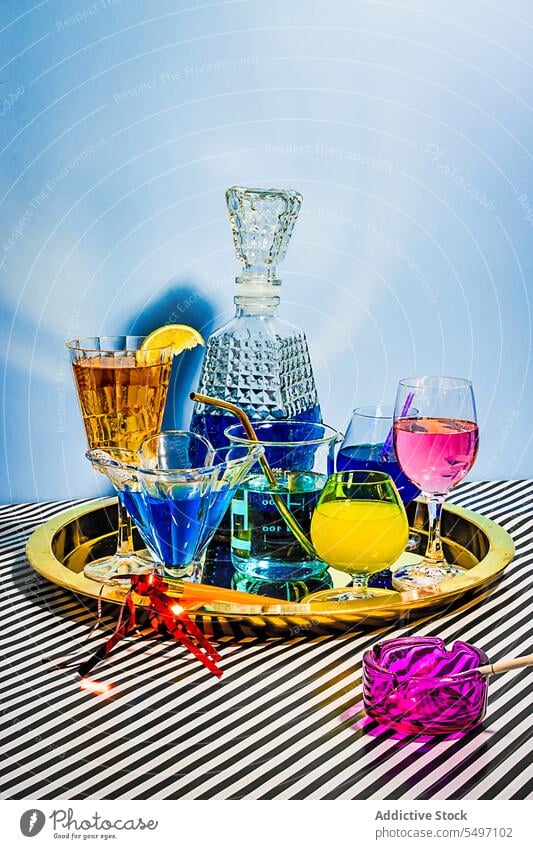 Variety of colorful cocktails in different glasses placed on plate in light tea drink beverage jar cold alcohol wine wineglass ice fabric glassware liquid