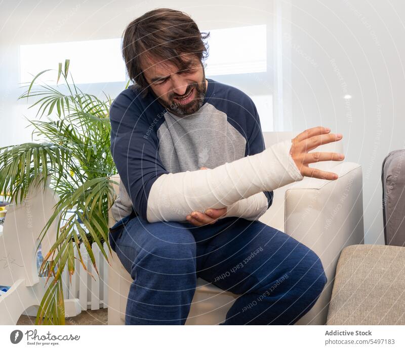 Man with bandages having arm pain man patient broken injury cast emergency hospital male physical orthopedic trauma fracture ache sore suffer struggle hurt